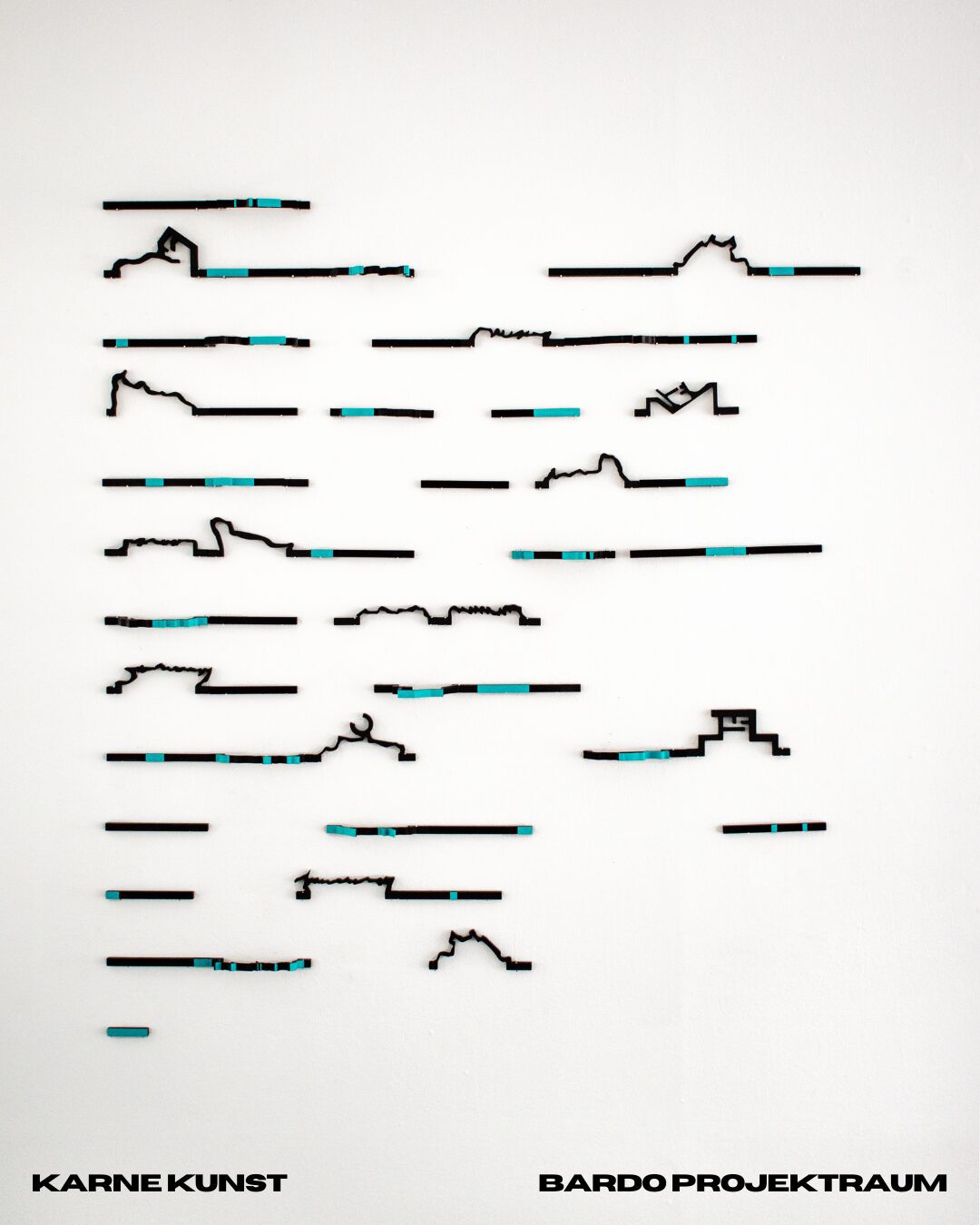 Wall installation of slender black linear forms punctuated with turquoise segments, arranged in rows across a white wall like lines of writing.